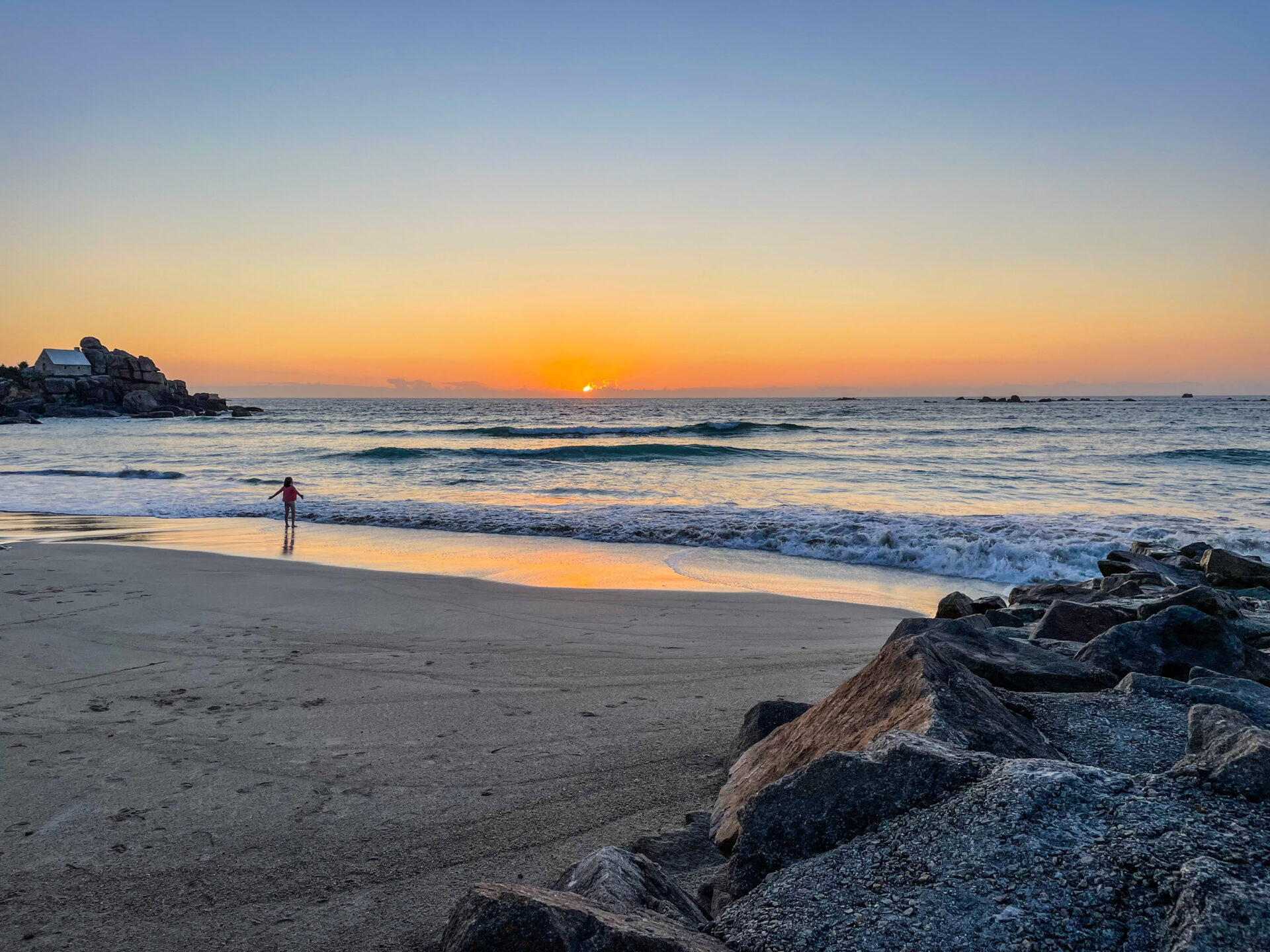 Kind am Meer bei Sonnenuntergang